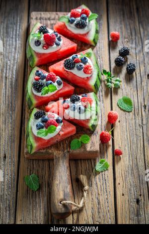 Pizza au melon d'eau juteuse et saine avec baies, crème fouettée et feuilles de menthe. Fruits fraîchement cueillis dans le jardin. Banque D'Images