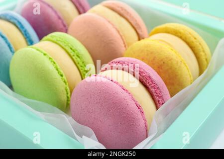 Beaucoup de délicieux macarons colorés dans la boîte, gros plan Banque D'Images