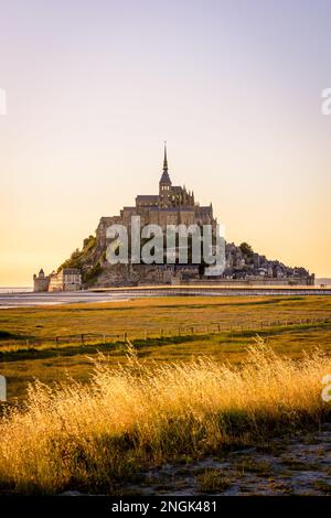 Vue au coucher du soleil sur l'île marémotrice du Mont Saint-Michel en Normandie, France, accessible depuis 2014 par la nouvelle jetée de 800 mètres de long sur pilotis. Banque D'Images