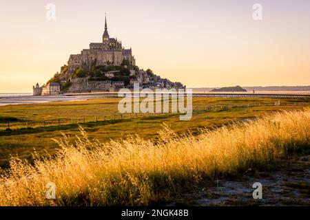 Vue au coucher du soleil sur l'île marémotrice du Mont Saint-Michel en Normandie, France, accessible depuis 2014 par la nouvelle jetée de 800 mètres de long sur pilotis. Banque D'Images