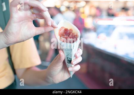 Hamon dans une main de femme au marché de rue. Jamon au marché de la Boqueria à Barcelone, Espagne. Marché le plus célèbre de Barcelone visité quotidiennement par des milliers de Banque D'Images