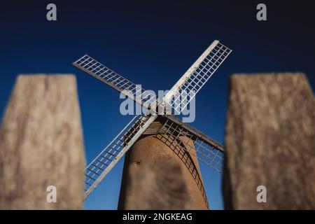 Le moulin à vent de bembridge se tenant au premier plan contre un ciel bleu vif Banque D'Images