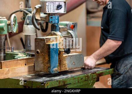 un artisan travaille sur une machine à bois dans un atelier de menuiserie Banque D'Images