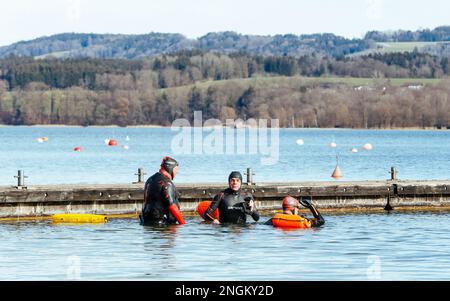 Stephanskirchen, Allemagne. 18th févr. 2023. Trois nageurs en eau libre retournent à une jetée après un tour à travers le lac Simsssee dans le quartier bavarois supérieur de Rosenheim à des températures printanières de 15 degrés au-dessus de zéro. Credit: Uwe Lein/dpa/Alay Live News Banque D'Images