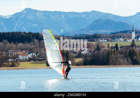 Stephanskirchen, Allemagne. 18th févr. 2023. Une planche à voile se déplace à des températures printanières de 15 degrés au-dessus de zéro, sur le lac Simsssee, dans le quartier de Rosenheim, en haute Bavière. Credit: Uwe Lein/dpa/Alay Live News Banque D'Images