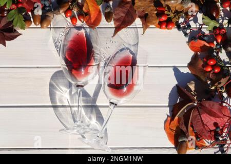 verre de vin rouge sur fond de bois avec feuilles d'automne et raisin Banque D'Images