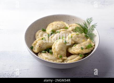 Boulettes végétaliennes maison, varéniki, pierogi, krechach farci avec des lentilles végétaliennes, carottes, oignons, herbes et épices sur fond texturé clair Banque D'Images