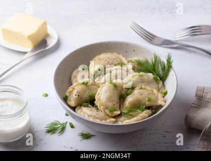 Boulettes végétaliennes maison, varéniki, pierogi, krechach farci avec des lentilles végétaliennes, carottes, oignons, herbes et épices sur fond texturé clair Banque D'Images