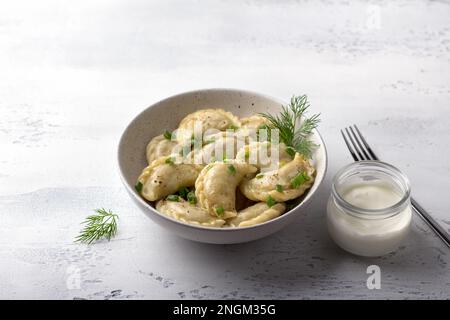 Boulettes végétaliennes maison, varéniki, pierogi, krechach farci avec des lentilles végétaliennes, carottes, oignons, herbes et épices sur fond texturé clair Banque D'Images