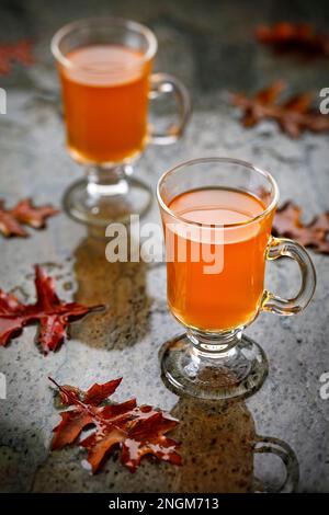punch de fruits sur sol humide avec des feuilles en automne Banque D'Images
