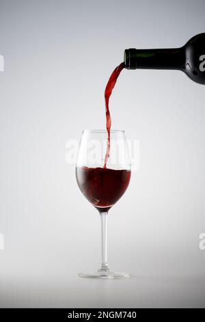 Verser le vin rouge dans un verre Banque D'Images