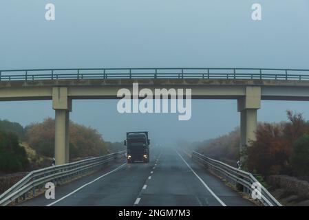 Conduite d'un camion sur une autoroute traditionnelle à deux voies par une journée brumeuse. Banque D'Images