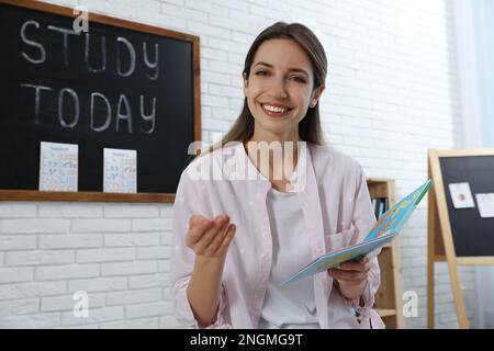 Bonne enseignante d'anglais féminine donnant la leçon à l'école primaire Banque D'Images