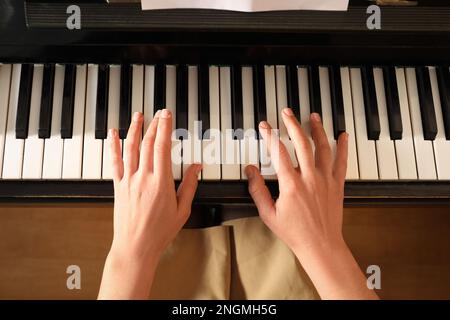 Jeune femme jouant du piano, au-dessus de la vue. Cours de musique Banque D'Images