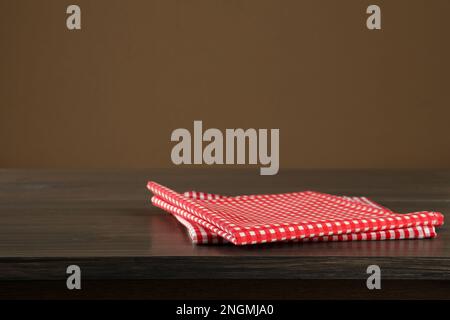 Serviettes à carreaux rouges et blancs sur bureau en bois, espace pour le design Banque D'Images