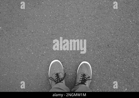 Pieds en chaussures de toile debout sur pied - rue de selfies vue personnel point de vue - Fond d'asphalte with copy space Banque D'Images