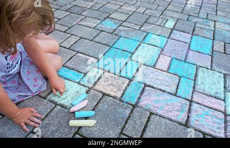 Peintures pour enfants à la craie colorée sur une chaussée en béton Banque D'Images