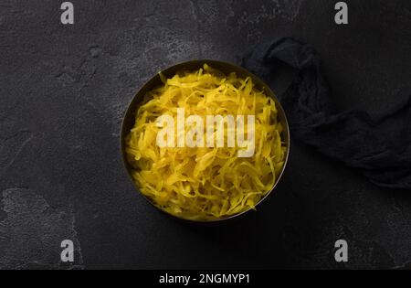 Choucroute maison à l'ail, à l'oignon et au curcuma sur fond texturé foncé. aliments fermentés sains, probiotiques naturels, aliments végétaliens. vue de dessus Banque D'Images