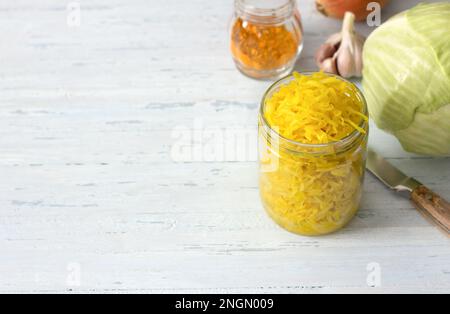 Choucroute maison à l'ail, à l'oignon et au curcuma sur fond bleu clair. aliments fermentés sains, probiotiques naturels, aliments végétaliens. vue de dessus, espace Banque D'Images