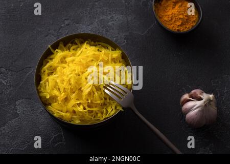 Choucroute maison à l'ail, à l'oignon et au curcuma sur fond texturé foncé. aliments fermentés sains, probiotiques naturels, aliments végétaliens. vue de dessus Banque D'Images