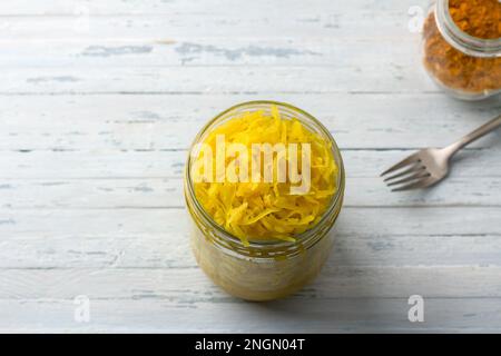 Choucroute maison à l'ail, à l'oignon et au curcuma sur fond bleu clair. aliments fermentés sains, probiotiques naturels, aliments végétaliens. vue de dessus, espace Banque D'Images