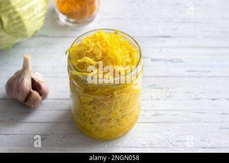 Choucroute maison à l'ail, à l'oignon et au curcuma sur fond bleu clair. aliments fermentés sains, probiotiques naturels, aliments végétaliens. vue de dessus, espace Banque D'Images