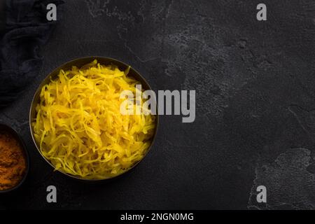 Choucroute maison à l'ail, à l'oignon et au curcuma sur fond texturé foncé. aliments fermentés sains, probiotiques naturels, aliments végétaliens. vue de dessus Banque D'Images