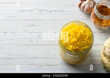 Choucroute maison à l'ail, à l'oignon et au curcuma sur fond bleu clair. aliments fermentés sains, probiotiques naturels, aliments végétaliens. vue de dessus, espace Banque D'Images