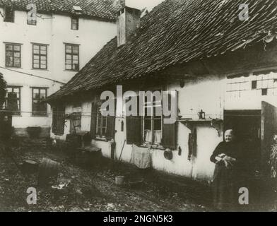 Bielefeld, Allemagne 1906 Burgstrasse. Femme aînée debout devant sa maison. Il ressemble plus à une ferme qu'à une maison de la ville. Il n'existe plus Banque D'Images