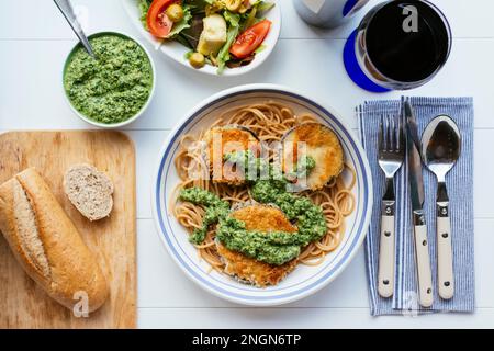 Plat avec aubergines panées maison et pesto aux épinards, servi sur spaghetti. Banque D'Images