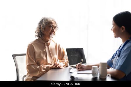 Infirmière asiatique vérifiant l'histoire de la maladie patient âgé soins aux patients âgés et santé mode de vie, concept médical Banque D'Images