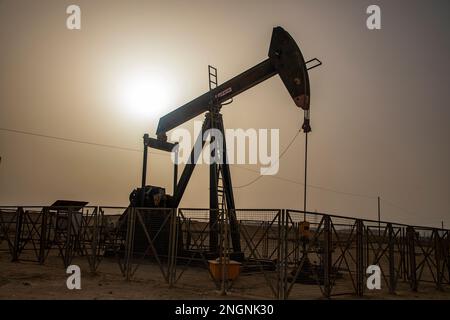 Pumpjack aka cheval de pétrole, hochement de tête, cric de pétrole, pompe à poutre élève le pétrole brut dans le désert de Bahreïn à Sakhir sur le golfe Persique. Banque D'Images