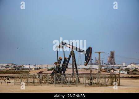 Pumpjack aka cheval de pétrole, hochement de tête, cric de pétrole, pompe à poutre élève le pétrole brut dans le désert de Bahreïn à Sakhir sur le golfe Persique. Banque D'Images