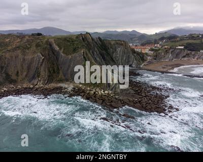 Vue sur les couches fortement inclinées de la formation géologique du flysme sur la côte atlantique à Zumaia à marée basse, pays basque, Espagne Banque D'Images