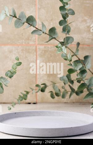 Vider le support décoratif en ciment et les branches d'eucalyptus sur la table, arrière-plan pour la présentation des cosmétiques et des produits. Banque D'Images