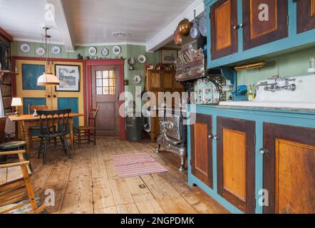 Pinewood avec armoires en bois de tilleul, ancien 1915 Belanger Royal poêle à bois et table à manger avec chaises assorties dans la vieille cuisine. Banque D'Images