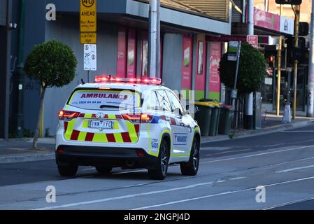 Vue arrière d'un véhicule ambulancier de Victoria, un Toyota Kluger, se précipitant vers une intersection où les feux de détresse clignotent Banque D'Images