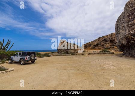 Belle vue sur la jeep blanche wrangler garée dans le parking des grottes de Kadirikiri Parc national d'Arikok. Aruba. Banque D'Images