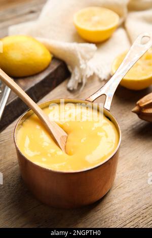 Délicieux citron caillé dans une casserole sur une table en bois Banque D'Images