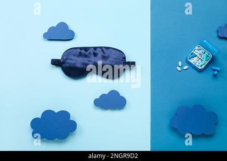 Composition avec masque de sommeil, pilules et nuages de papier sur fond de couleur. Concept de la Journée mondiale du sommeil Banque D'Images