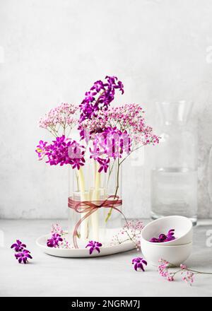 Magnifique arrangement floristique de printemps avec jacinthe pourpre, et fleurs de gitsophila rose dans un vase en verre. Décoration maison pour Pâques, Fête des mères. Banque D'Images