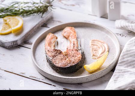 steak de saumon grillé aux épices. il y a du romarin et une tranche de citron à proximité Banque D'Images