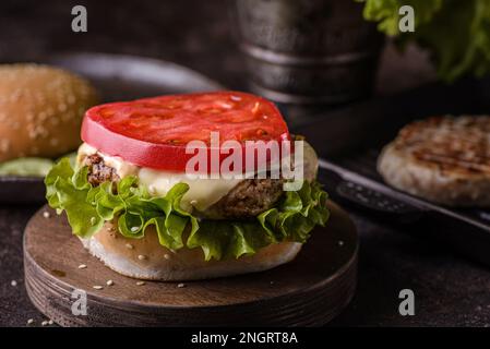 Hamburger sur une planche en bois, hamburger ouvert sans pain supérieur Banque D'Images