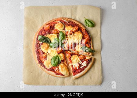 Pizza Margarita avec fromage et tomates et basilic sur parchemin. Photo de haute qualité Banque D'Images