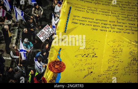 Tel Aviv, Israël. 18th févr. 2023. Les manifestants marchent avec la copie de la déclaration d'indépendance d'Israël et les drapeaux pendant la manifestation. Les gens ont protesté à tel Aviv contre le gouvernement de droite du Premier ministre Benjamin Netanyahu et contre sa réforme juridique controversée. La réforme juridique proposée permettrait au Parlement de renverser la décision de la Cour suprême par un vote à la majorité parmi les législateurs de 120 sièges. Toutefois, ils nomment des juges, qui renforcent leur influence politique sur le système. Crédit : SOPA Images Limited/Alamy Live News Banque D'Images