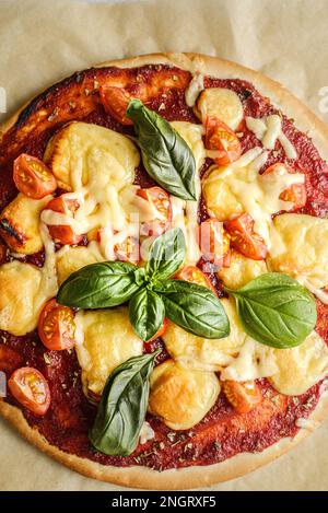 Pizza Margarita avec fromage et tomates et basilic sur parchemin. Photo de haute qualité Banque D'Images