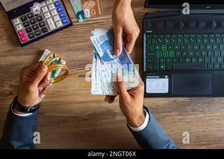 Homme d'affaires main traitant avec le Pakistan Ruppee monnaie billets et l'or pour économiser le budget d'investissement d'argent et la gestion de comptabilité financière ou de grandir Banque D'Images