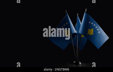 Petits drapeaux nationaux du Kosovo sur fond noir. Banque D'Images