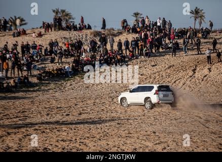 Gaza, Palestine. 17th févr. 2023. Les Palestiniens observent les conducteurs de véhicules à quatre roues motrices lors de la « dérive hebdomadaire » sur les collines sablonneuses de la ville de Rafah, dans le sud de la bande de Gaza. Crédit : SOPA Images Limited/Alamy Live News Banque D'Images