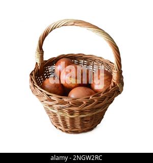 Panier de Pâques avec œufs de Pâques naturellement teints isolés sur fond blanc Banque D'Images